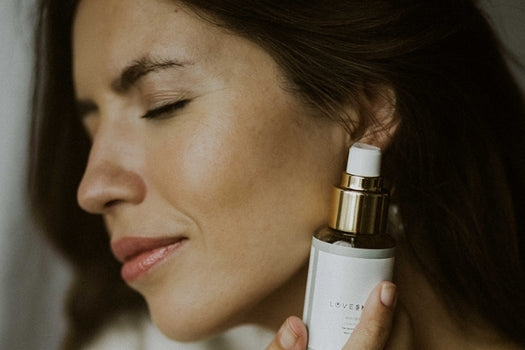 Woman holding tui oil based facial cleanser by face