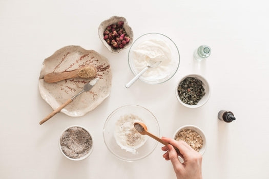 clay mask ingredients in bowls being mixed