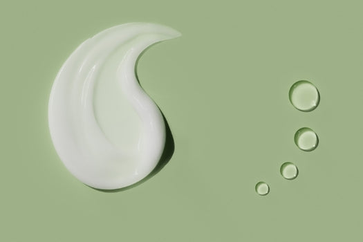 face cream and face oil on green background