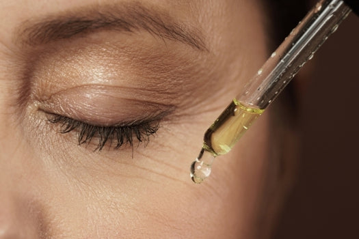 Holding natural oil dropper close up in front of cheek
