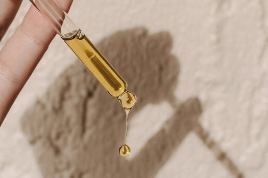 Dispensing natural botanical oil serum from glass dropper