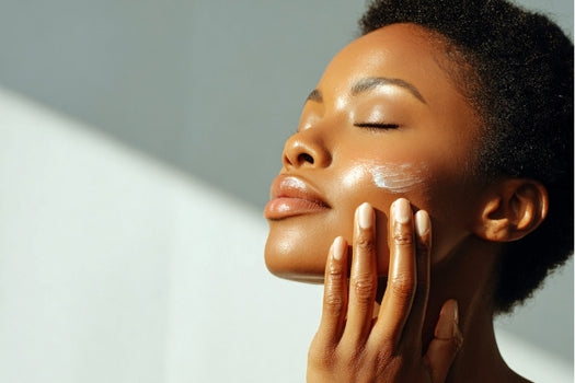Woman applying natural skincare moisturiser to her cheek