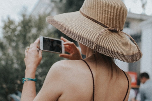 Woman wearing large sunsmart hat to protect skin while taking photo
