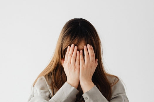 Woman holding face in palms dealing with problem skin
