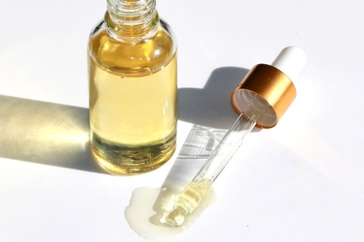 bottle of natural facial serum with glass dropper on white background