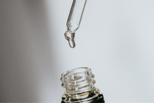 skincare oil dropper dispensing into bottle