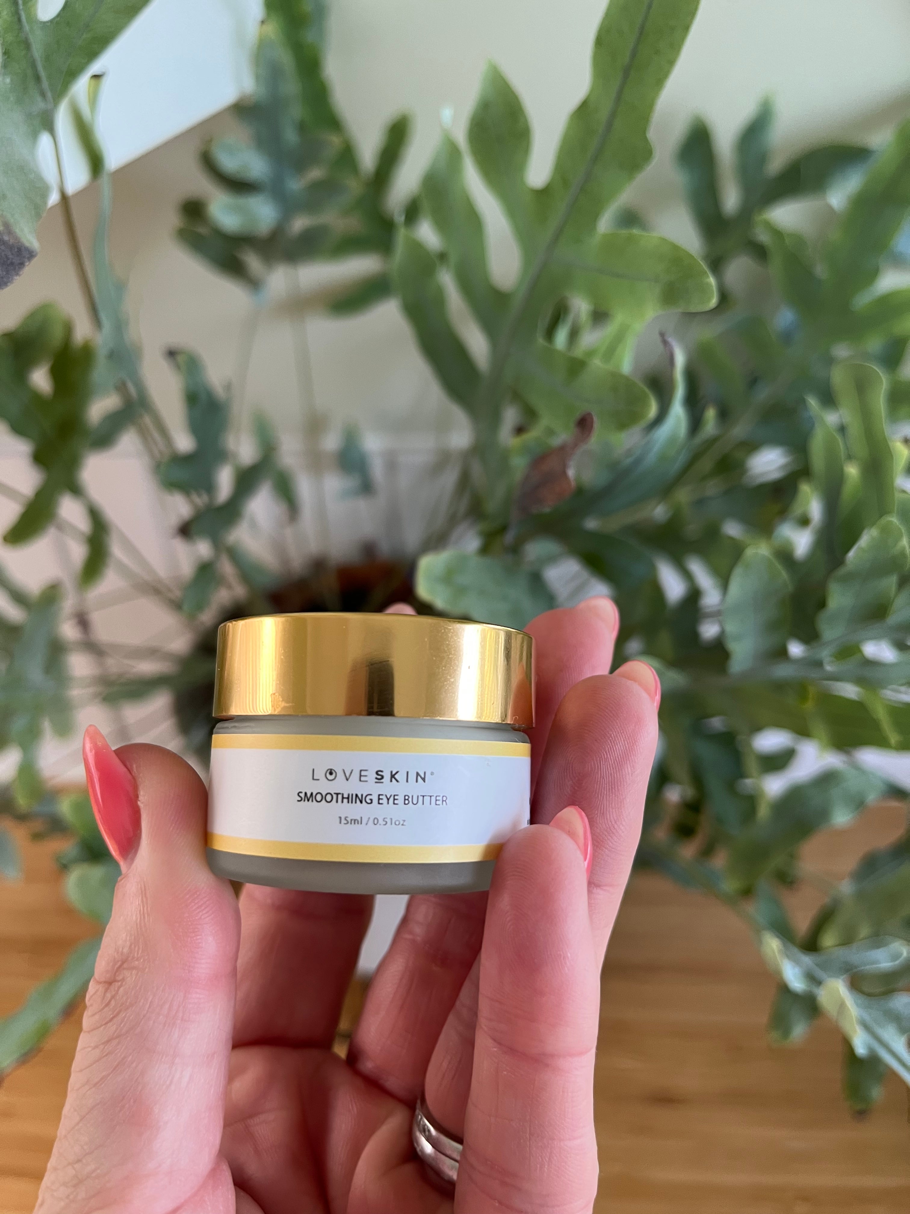 Hand holding a LOVESKIN's hydrating eye cream.