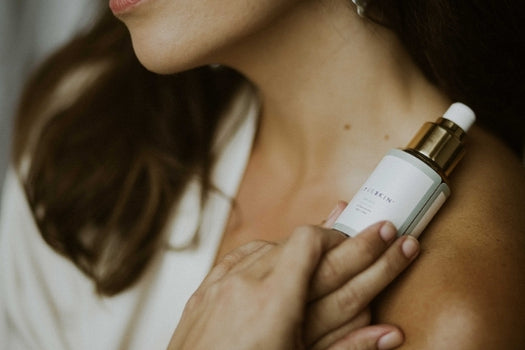 woman holding tui cleanser up to her neck and chest