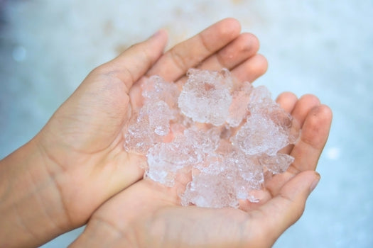 hands holding ice to use for facial icing