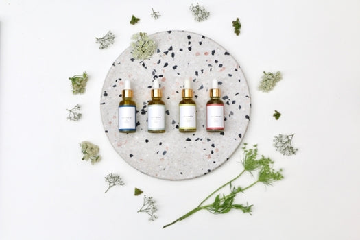 4 natural skincare oil bottles laid out
