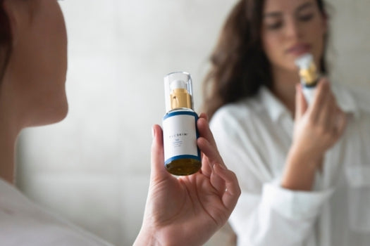 reflection of woman holding bottle of tui facial cleanser in mirror