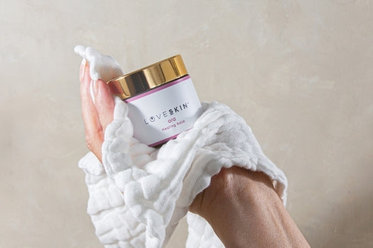 LOVESKIN Ora balm and muslin cloth in hand, used for skin slugging