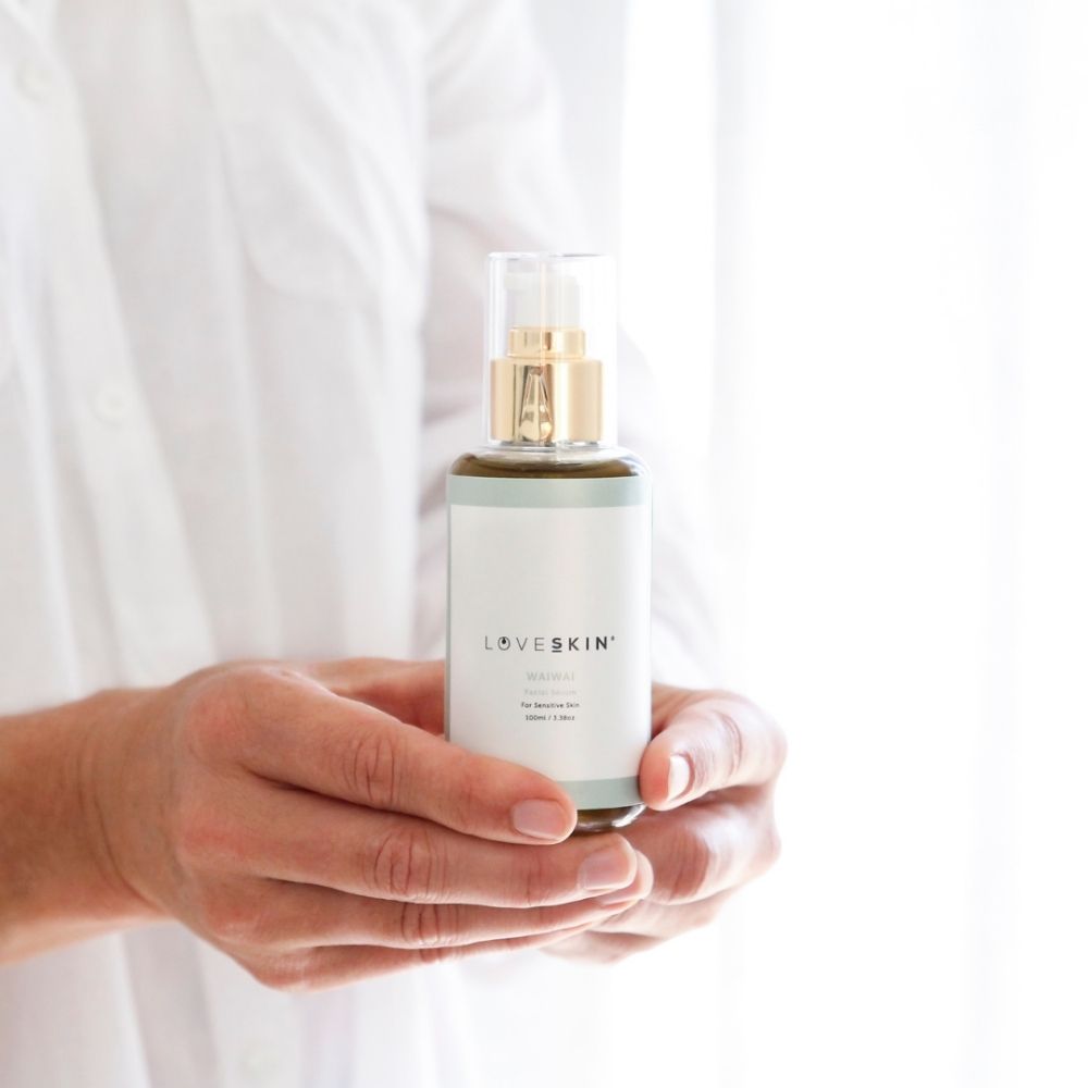 Holding a bottle of Waiwai Serum for sensitive skin 