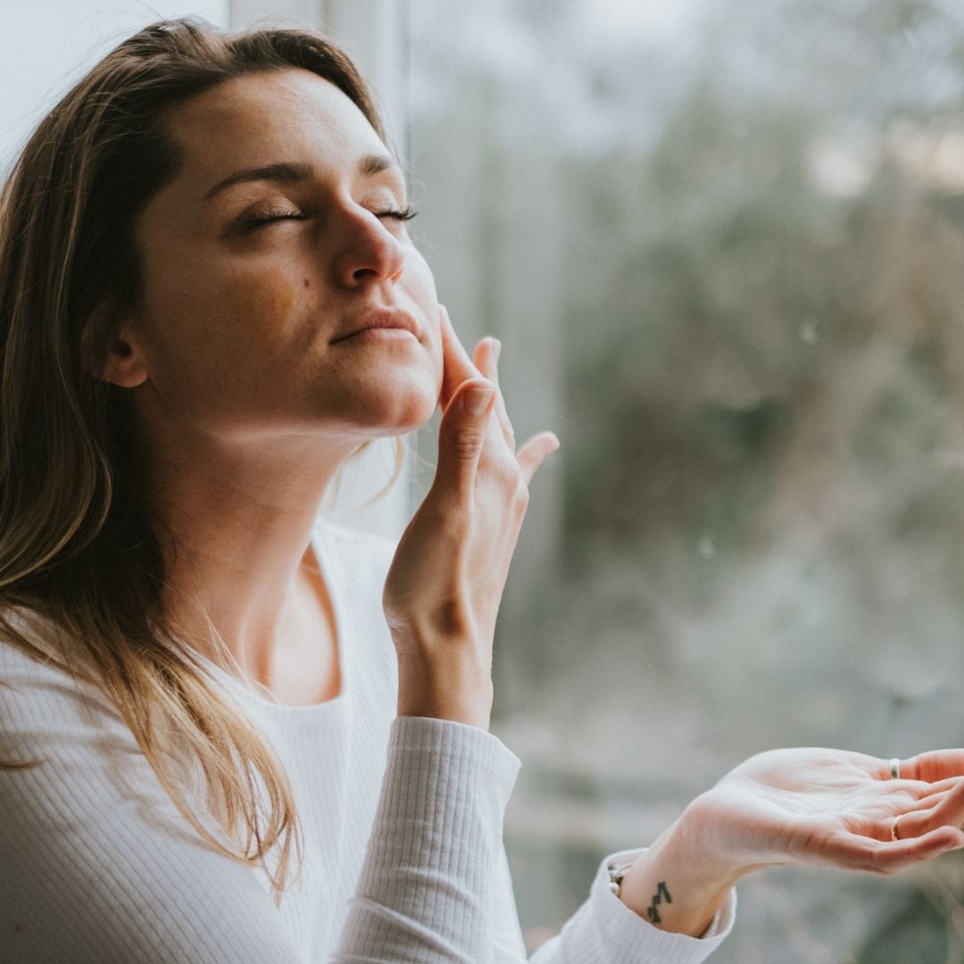 Woman applying the hydrating Arohanui facial serum for glowing skin