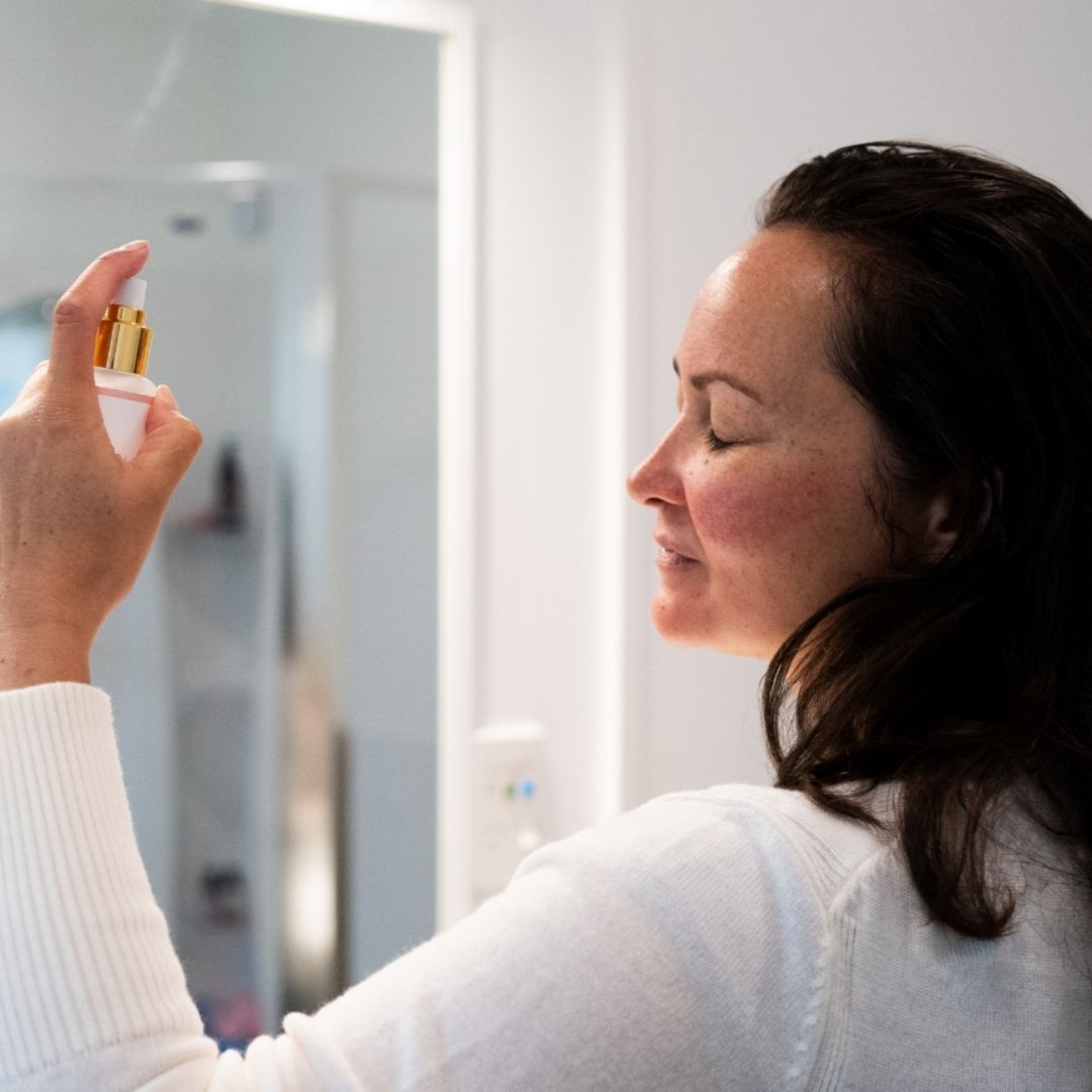 Woman spraying refreshing Kakara Rose Mist 
