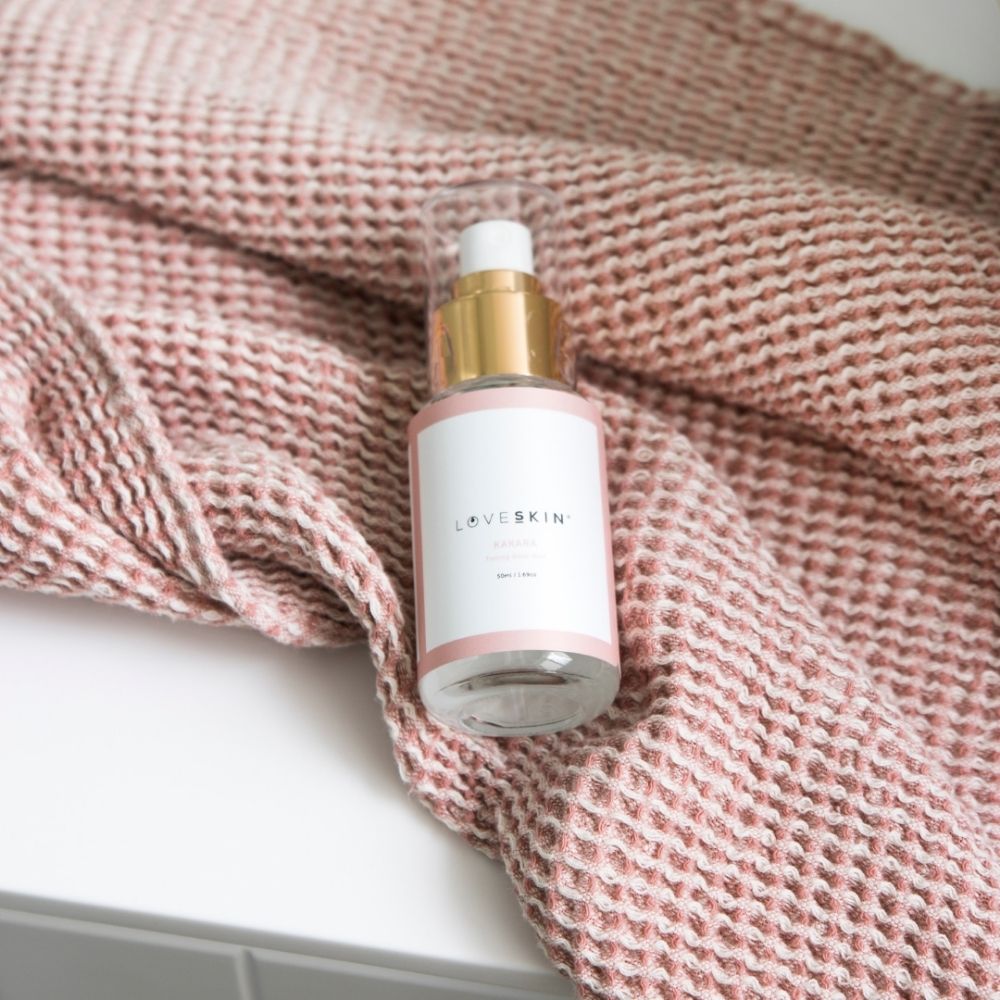 LoveSkin Kakara Rose Mist bottle on soft pink textured fabric